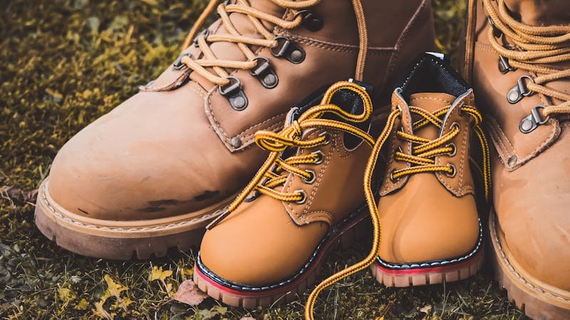 Botas de campo sobre hierba verde preparadas para un campamento